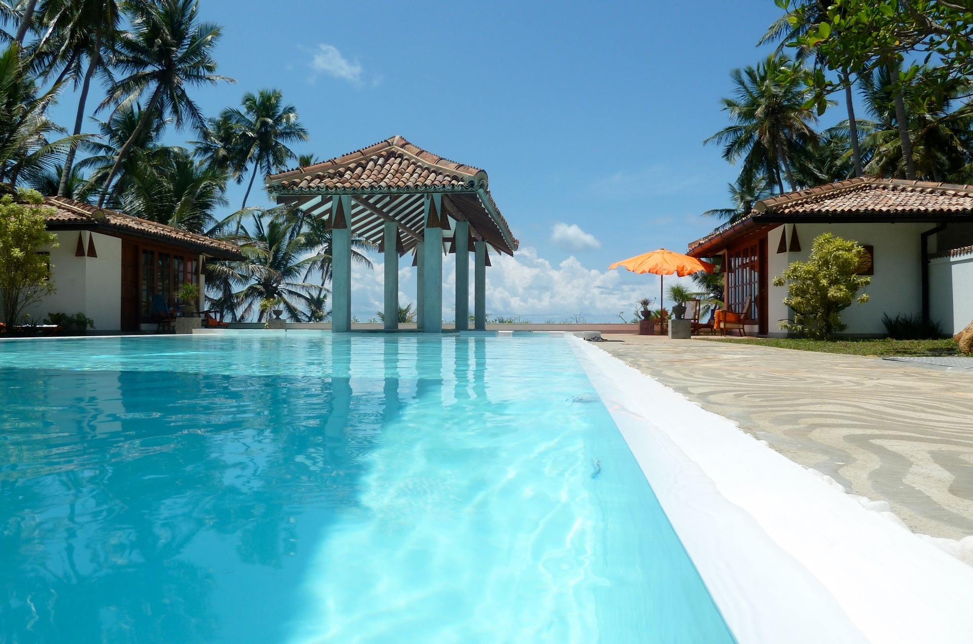Vom Ayurveda-Restaurant der Shakti Villa auf Sri Lanka, blickt man über den Pool bis zum Horizont.